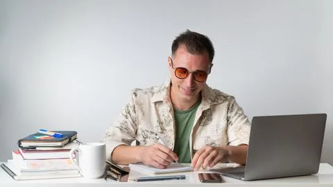Hipster student writes in a notebook behind the workplace for learning Stock Photos