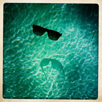 Hipster Sunglasses Floating in a Pool Stock Photos