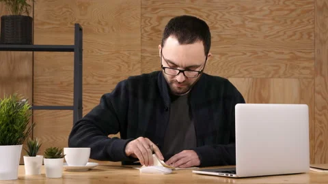 Hipster taking notes down from his new laptop computer while browsing the 스톡 동영상 114203762