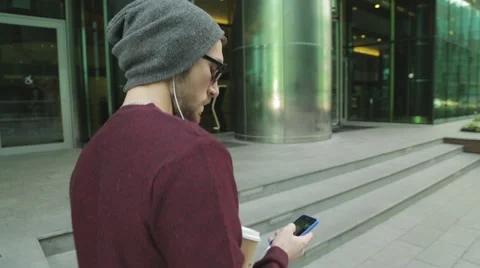 Hipster using app and listening to music in smartphone headphones Stock-Footage 68398842