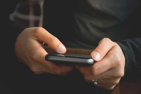 Hipster using a touch screen smart phone hands close up, vintage colors Stock Photos