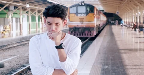 Hipster waitng for train in train station, with train in backgorund, in Bangkok. Stock Footage 106385114