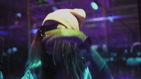 A hipster woman dances and makes a selfie. Bright light and changing colors Stock Footage 83781753