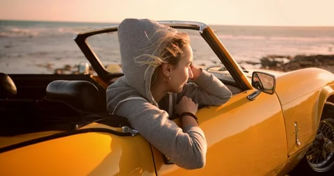 Hipster woman relaxing in convertible car and looking at sunset Stock Footage