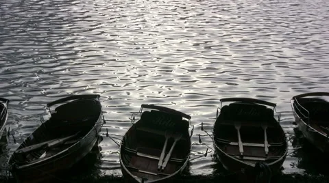 Hire rowing boats, backlit by the setting sun,on the shore of Lake Windermere Stock Footage 51151398