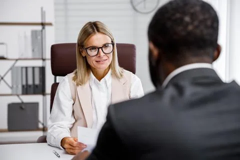 Hiring, interview. Middle-aged blond business woman conducting an interview in a Stock Photos