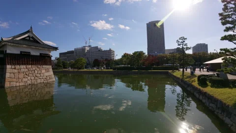 Hiroshima Castle moat reflecting the surrounding modern city buildings Stock Footage 335574364