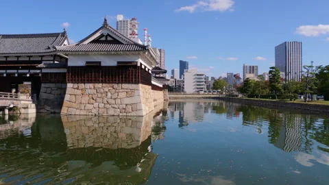 Hiroshima Castle moat reflecting the surrounding modern city buildings Stock-Footage 335590809