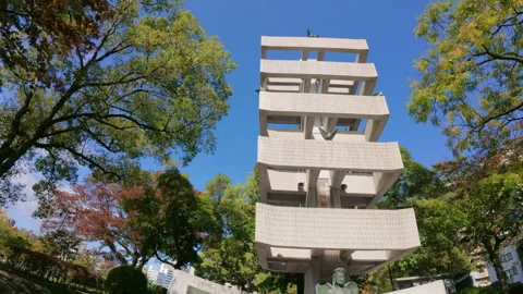 Hiroshima Peace Memorial Tower among green trees and blue sky 動画素材 335537243