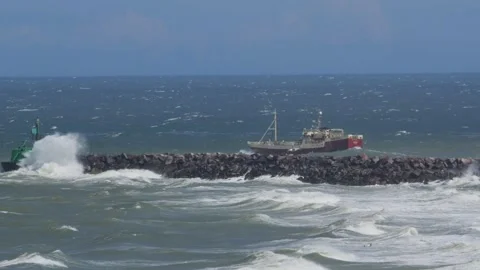 Hirthals, Denmark - July 06, 2026: Fishing trawler in rough sea near breakwater Stock Footage 338329415
