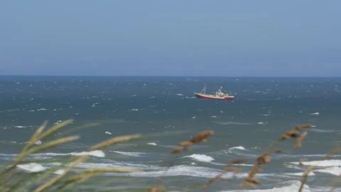 Hirthals, Denmark - July 06, 2026: Fishing trawler navigating choppy sea waves Stock Footage 338329585