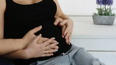 His and her hand stroking the belly of a pregnant young woman. Slow motion Stock Footage 61631069