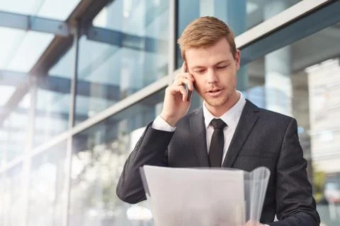His cellphone keeps him in touch with the office Stock Photos