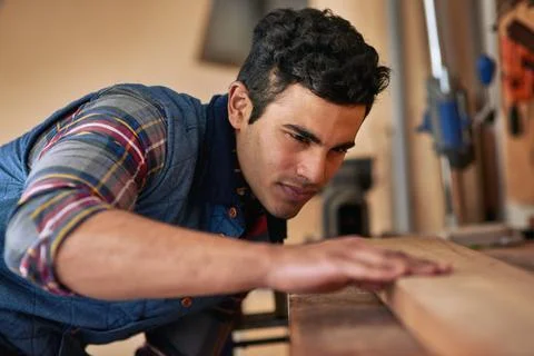 His commitment to detail makes him a great carpenter. a focused handyman 库存照片