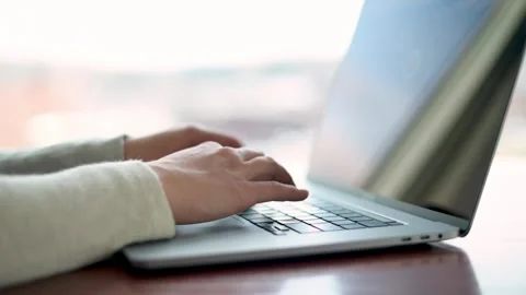 His compelling video captures a close view of a woman's hands on a laptop key Video stock 275004159
