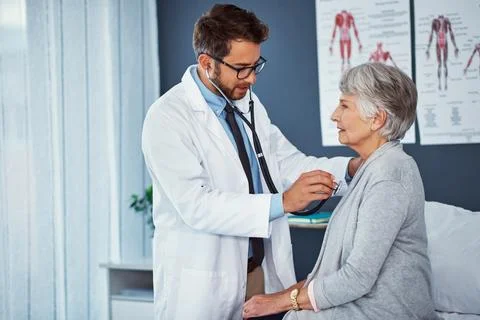 His duty is to make a difference. a doctor examining a senior patient with a Stock Photos