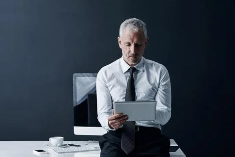 His entire database at the touch of a button. a mature businessman working on Stock Photos