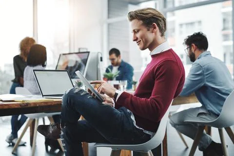 His work adds so much value to the team. a young businessman using a digital Stock Photos