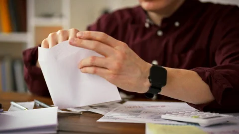 At his work desk a mans hands carefully sort crisp banknotes into individual Stock Footage 345527631