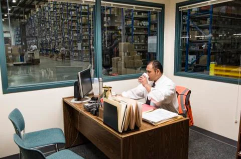 Hispanic American executive working on a computer in an office in the middle of Stock Photos
