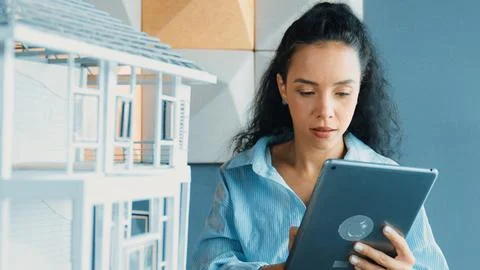 Hispanic architect drawing building construction by using tablet. Manipulator. Stock Photos
