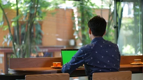 Hispanic attractive man sitting in coffee shop with a laptop drinking coffee Vídeo Stock 101656319