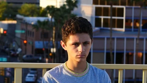 Hispanic boy in deep thought in an urban setting Stock Footage 80117084