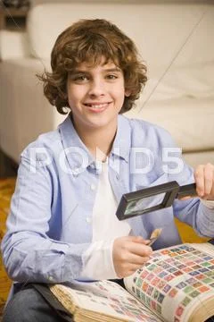 Hispanic boy holding stamp and magnifying glass Stock Photos