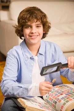 Hispanic boy holding stamp and magnifying glass Stock Photos