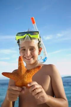 Hispanic boy holding starfish Stock Photos
