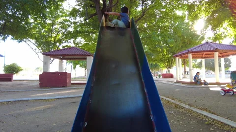 Hispanic boy playing in a playground on a slide very happy Video stock 263874700