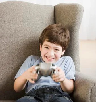 Hispanic boy playing video games Stock Photos