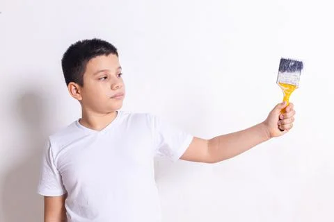 Hispanic boy points with paint brush Stock Photos