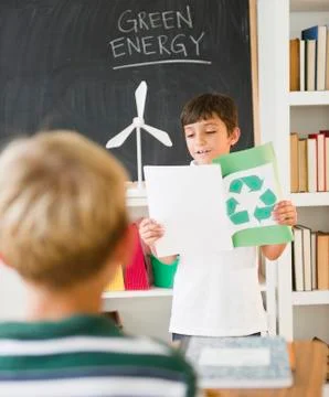 Hispanic boy reading recycling report in classroom Stock Photos