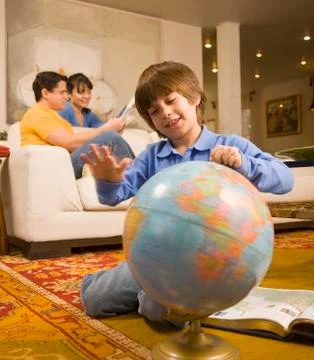 Hispanic boy spinning globe Stock Photos
