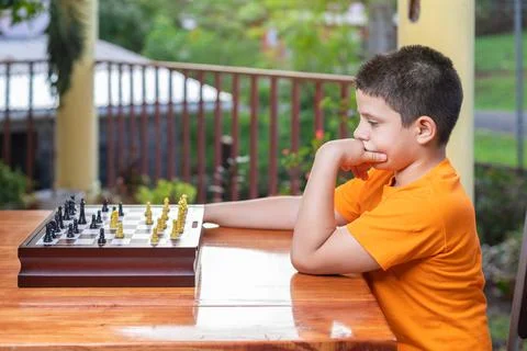 Hispanic boy thinking which piece to move on the board Stock Photos