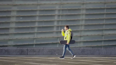 Hispanic boy walking while holding skateboard Stock Footage 222572202