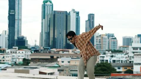 Hispanic break dancer practice B-boy footsteps at roof top with city. Endeavor. 스톡 사진