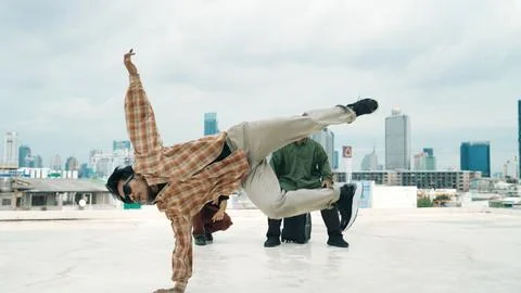 Hispanic break dancer practice B boy dance with friends at roof top. Endeavor. Stock Photos