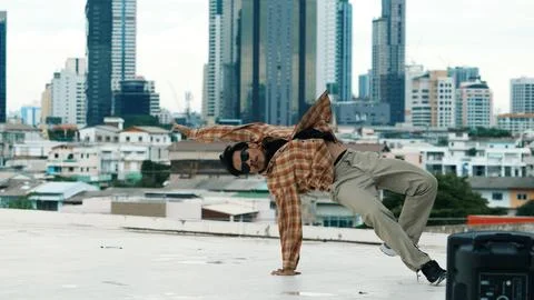 Hispanic break dancer practice B boy dance with friends at roof top. Endeavor. Stock Photos