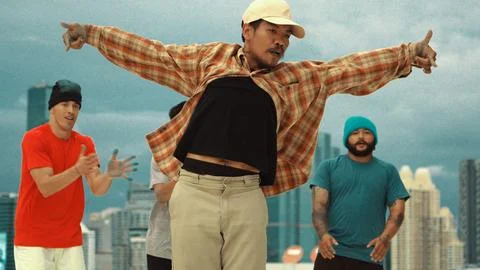 Hispanic break dancer practice B boy dance with friends at roof top. Endeavor. Stock Photos