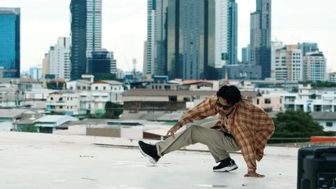 Hispanic break dancer practice B boy dance with friends at roof top. Endeavor. 写真素材