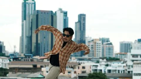 Hispanic break dancer practice B-boy footsteps at roof top with city. Endeavor. 写真素材