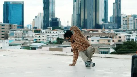 Hispanic break dancer practice B boy dance with friends at roof top. Hiphop. Stock Photos