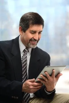 Hispanic Businessman Using Elecroni Tablet Stock Photos
