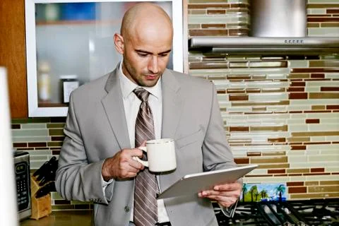 Hispanic businessman using tablet computer in kitchen 스톡 사진