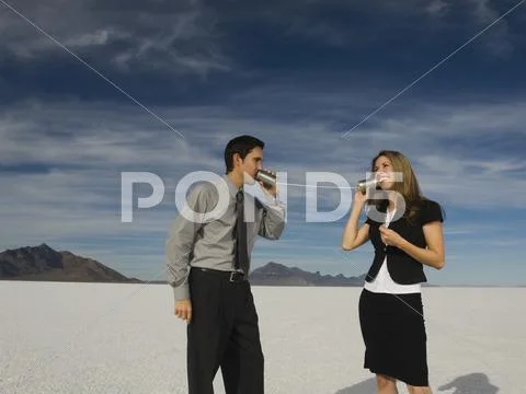 Hispanic Businesspeople Talking On Can And String Telephone
