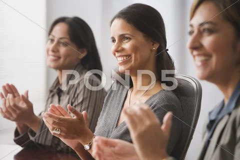 Hispanic businesswomen clapping Stock Photos