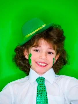 Hispanic child boy having fun during Saint Patrick celebrations over a green  Stock Photos