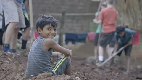 Hispanic child turning around looking at camera with mission team in background Stock Footage 234361908
